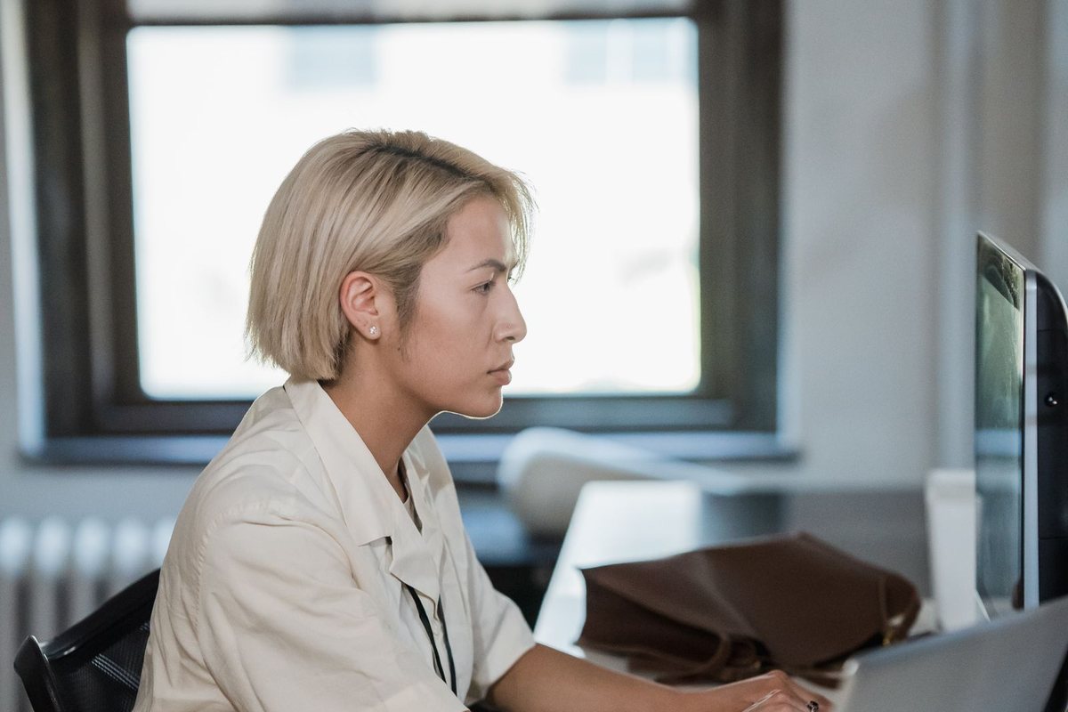 A woman typing on a laptop at her desk