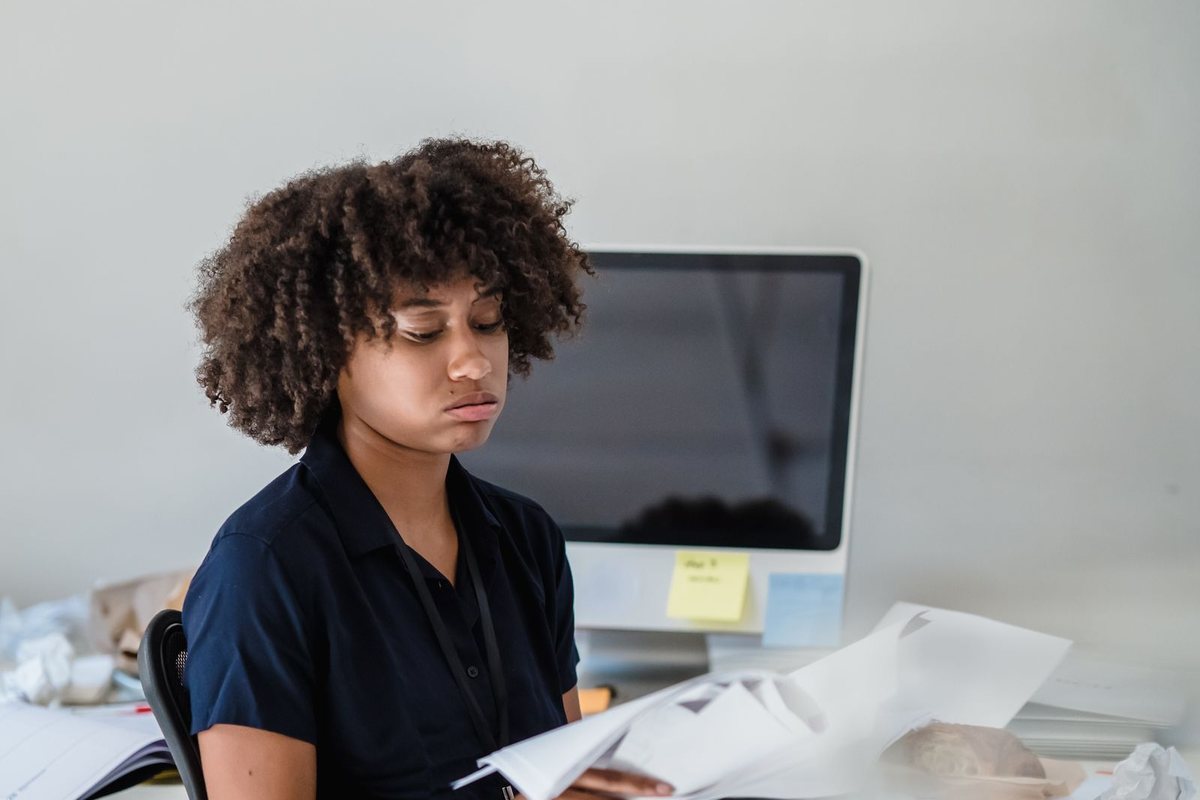 A woman reading through documents at her desk